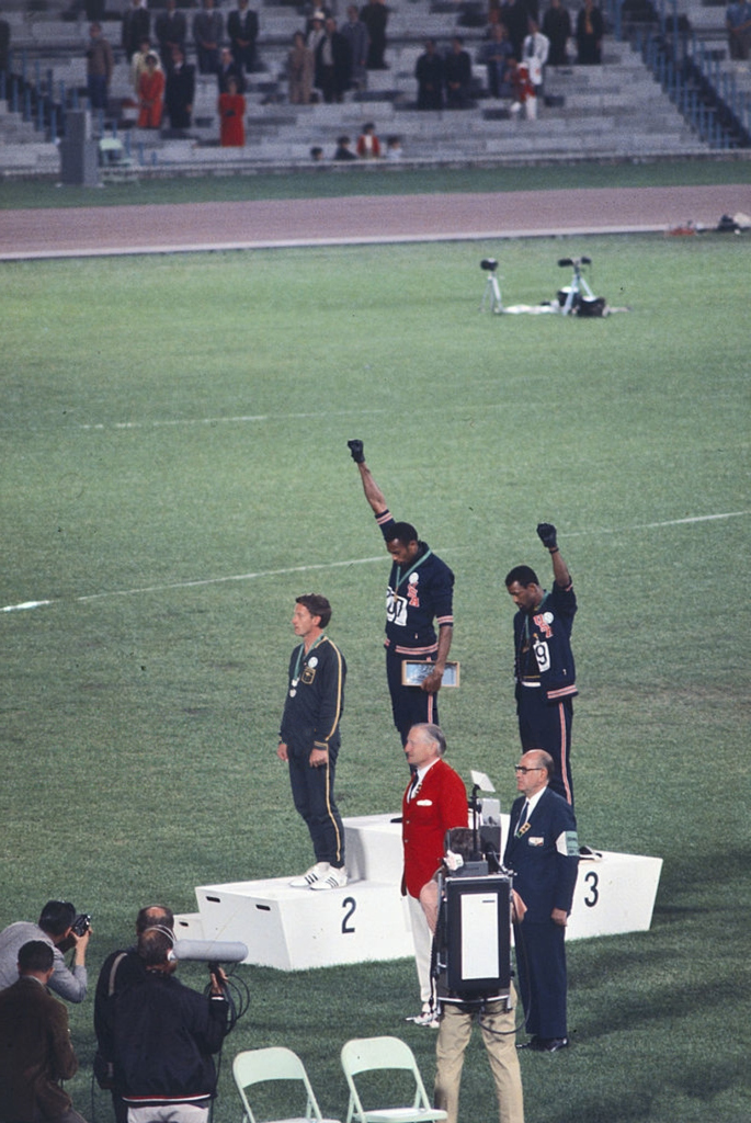 The american sprinters Tommie Smith,John Carlos and Peter Norman during the award ceremony of the 200 m race at the Mexican Olympic games. During the awards ceremony, Smith and Carlos protested against racial discrimination: they went barefoot on the podium and listened to their anthem bowing their heads and raising a fist with a black glove. Mexico City, Mexico, 1968 Mexico city, Mexico, 1968