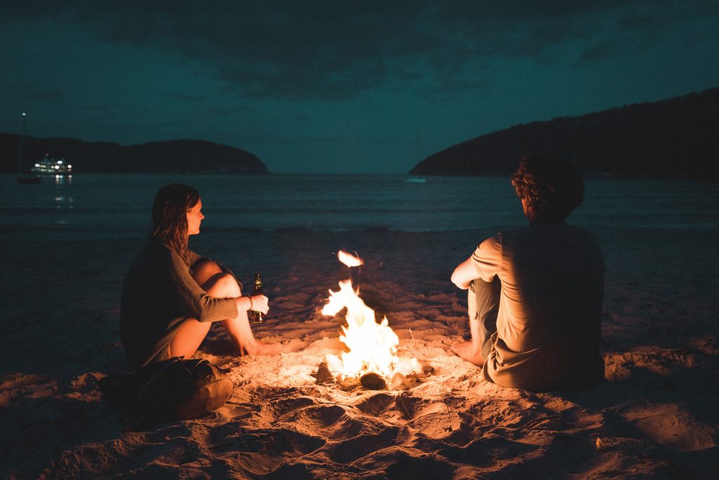 couple sitting on a beach in the dark
