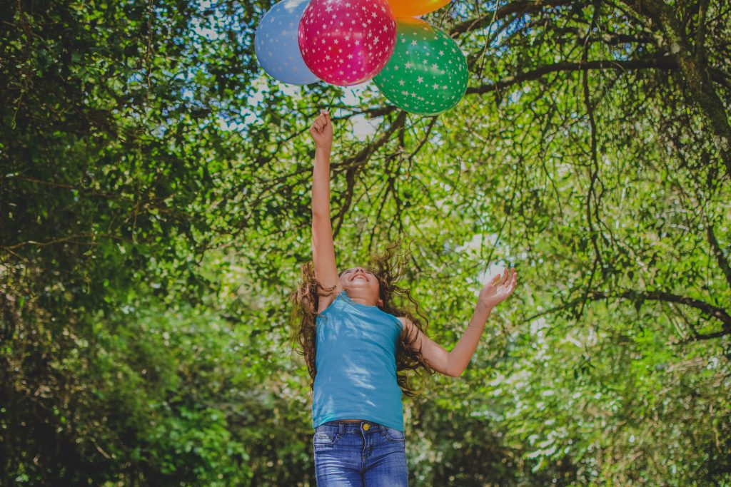 a girl playing with baloons to signify the right to play