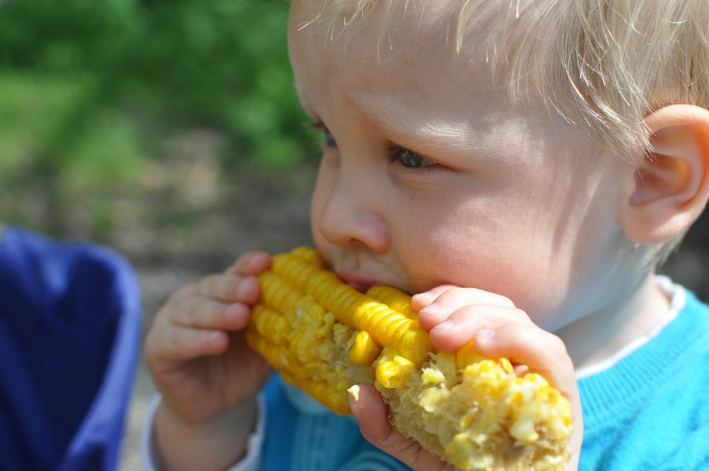 A child eats some sweetcorn