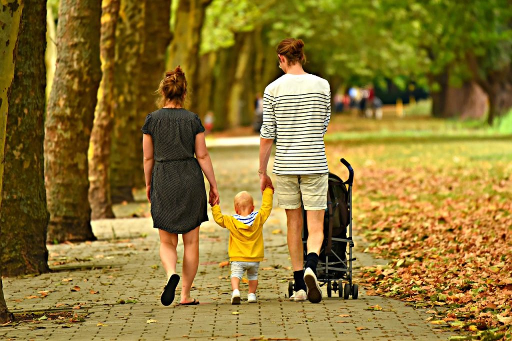 Two parents walk with their child